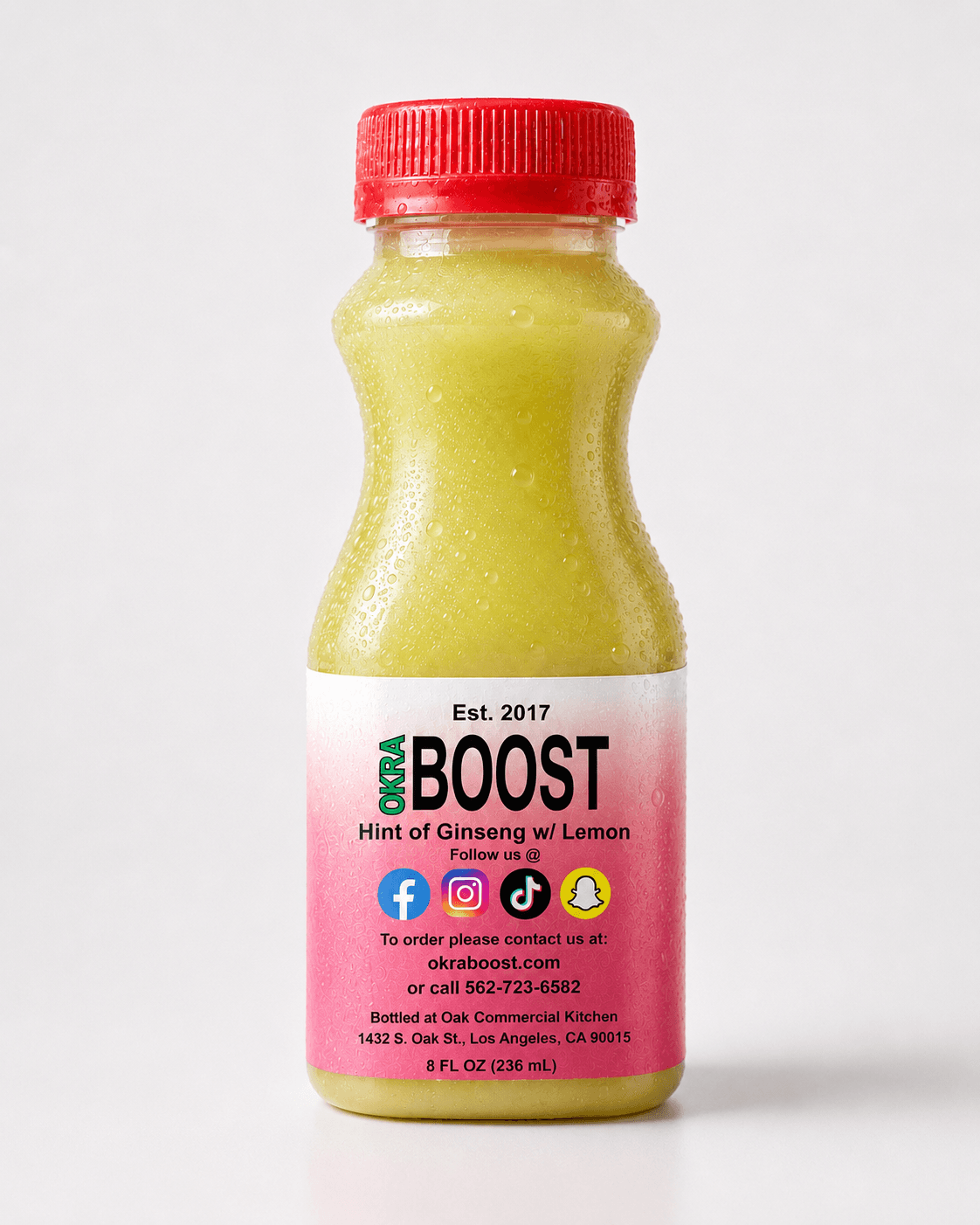 Okra Boost Ginseng-Lemon: orange-cap bottle, herbal ginseng and lemon blend, clean white studio backdrop